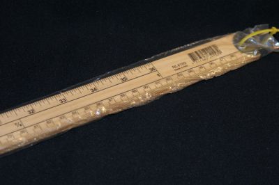 A ONE METRE WOODEN RULE WITH INCHES